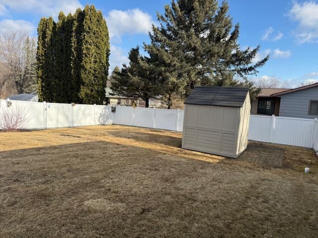 view of yard with a fenced backyard, an outdoor structure, and a shed