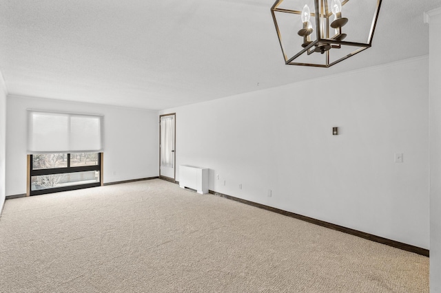 unfurnished room with radiator heating unit, carpet, baseboards, and a chandelier