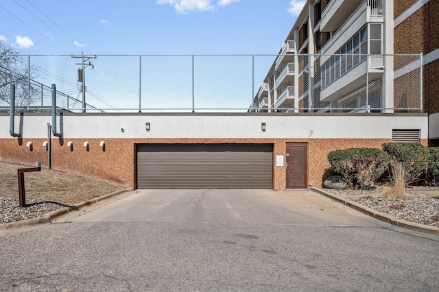 exterior space with concrete driveway, a garage, and stucco siding