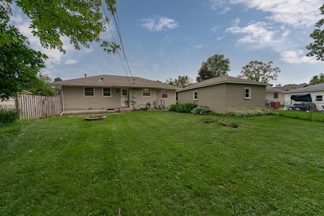 back of house featuring a lawn and fence