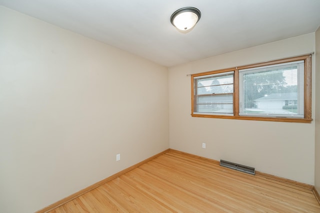 unfurnished room featuring a wealth of natural light, visible vents, baseboards, and light wood-style floors