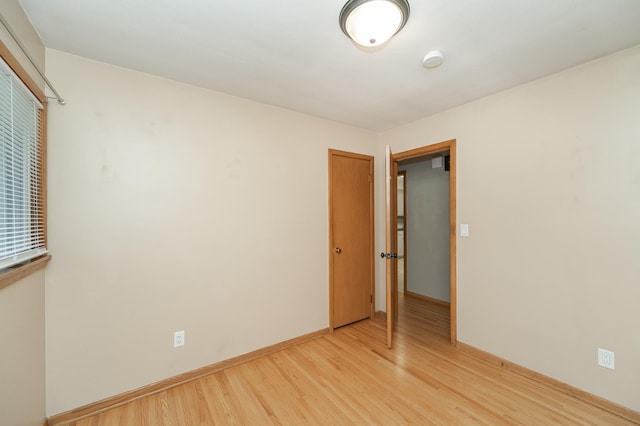 spare room featuring light wood-type flooring and baseboards