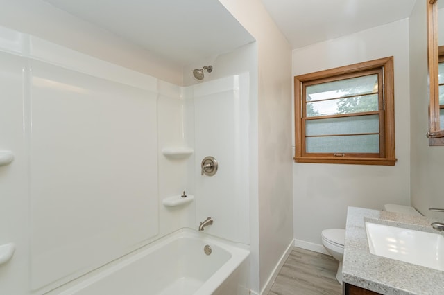 full bathroom featuring vanity, wood finished floors, baseboards, shower / bath combination, and toilet