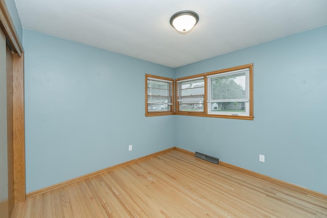 unfurnished room with visible vents, baseboards, and wood finished floors