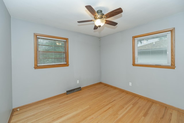 empty room featuring visible vents, baseboards, wood finished floors, and a ceiling fan