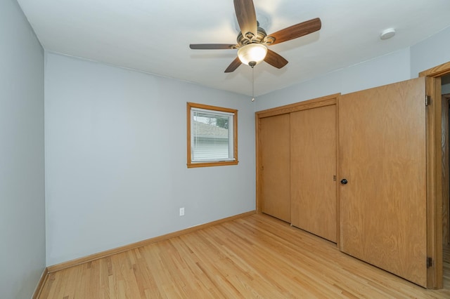 unfurnished bedroom featuring a ceiling fan, baseboards, light wood-type flooring, and a closet