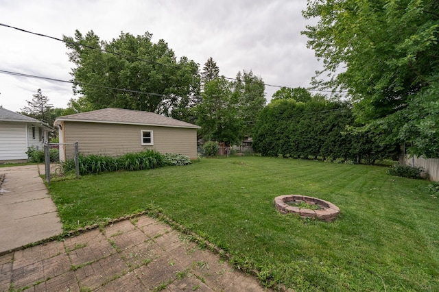 view of yard with fence and an outdoor fire pit