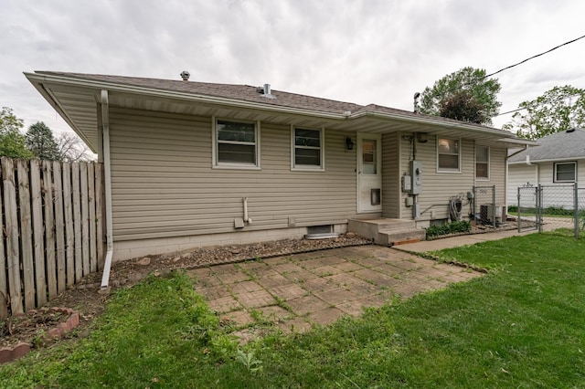 rear view of house featuring a yard, central AC, and fence