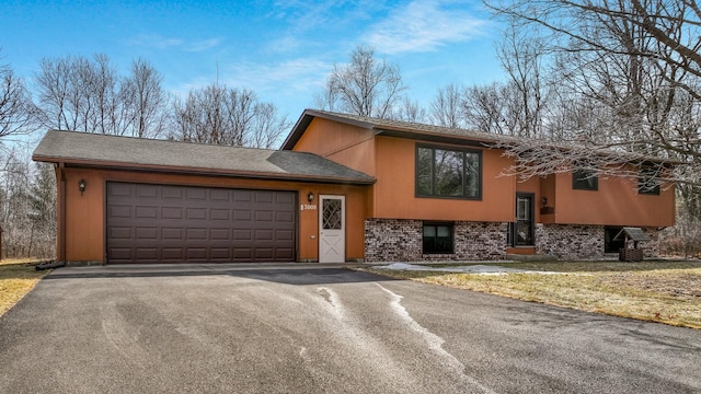 view of front of house featuring driveway, brick siding, and an attached garage