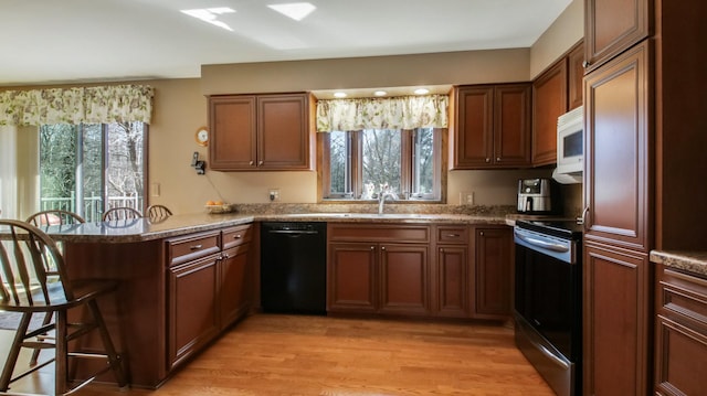 kitchen with electric stove, a kitchen breakfast bar, black dishwasher, a peninsula, and white microwave