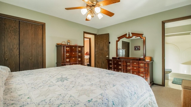 carpeted bedroom featuring a closet, ensuite bath, and ceiling fan