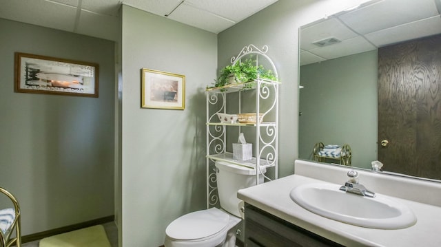 bathroom with vanity, toilet, visible vents, and a drop ceiling