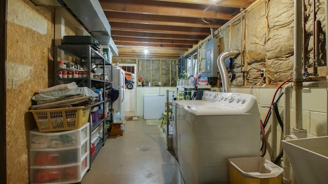 basement with electric panel, freestanding refrigerator, independent washer and dryer, fridge, and a sink