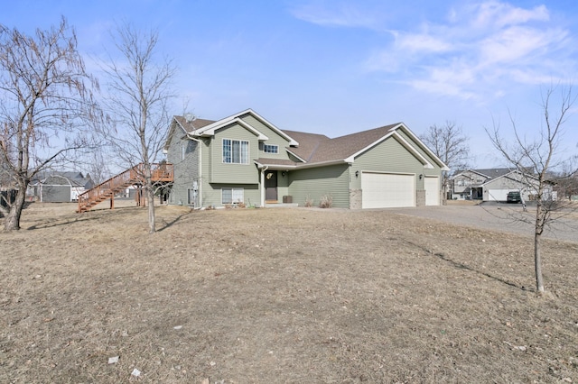 view of front of home with stairway, an attached garage, and driveway