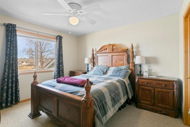 bedroom featuring ceiling fan, a textured ceiling, and light carpet