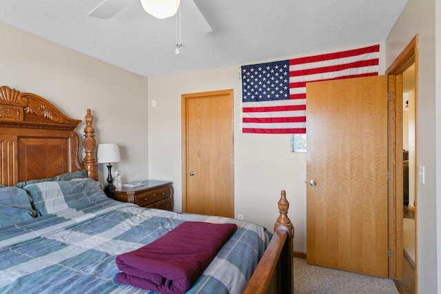 bedroom featuring ceiling fan, carpet flooring, and a textured ceiling