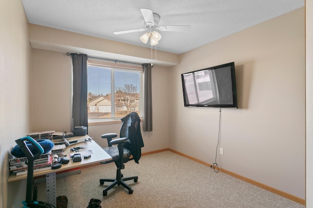 office space with baseboards, a textured ceiling, carpet floors, and a ceiling fan