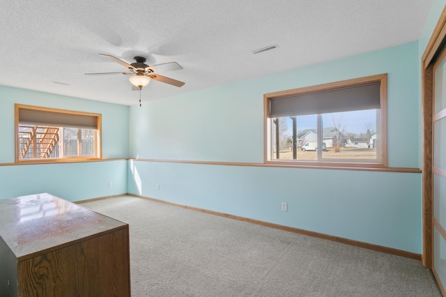 interior space featuring visible vents, carpet floors, a textured ceiling, and baseboards