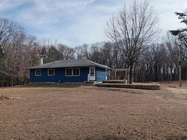 single story home with a chimney and a wooden deck