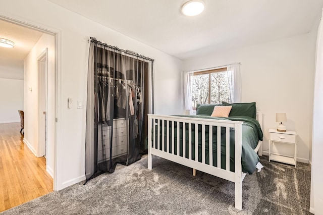 carpeted bedroom with baseboards and a closet