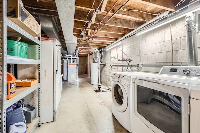 washroom featuring heating unit, water heater, washer and dryer, and laundry area