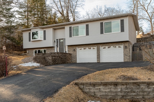 bi-level home with aphalt driveway and an attached garage