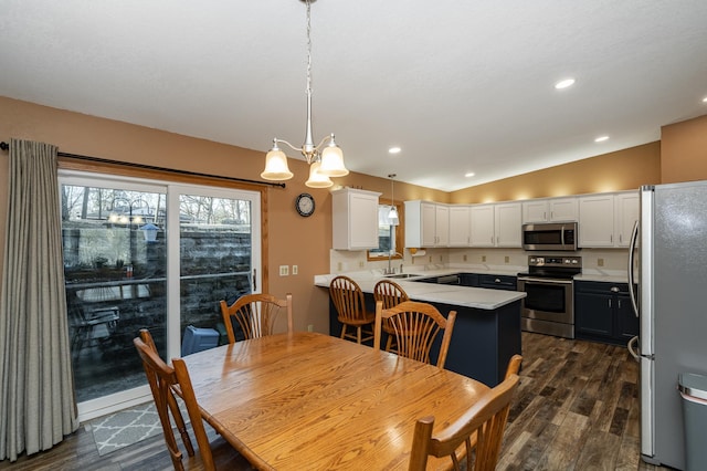 dining area with recessed lighting, lofted ceiling, an inviting chandelier, and dark wood finished floors