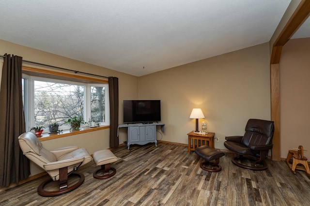 sitting room with baseboards and wood finished floors