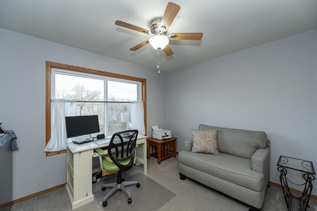 office area with a ceiling fan, carpet, baseboards, and a textured ceiling