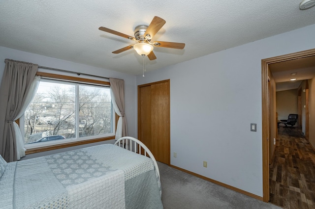 bedroom with ceiling fan, baseboards, a closet, and a textured ceiling