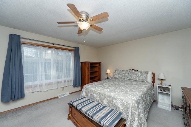 bedroom featuring visible vents, carpet flooring, a textured ceiling, and baseboards