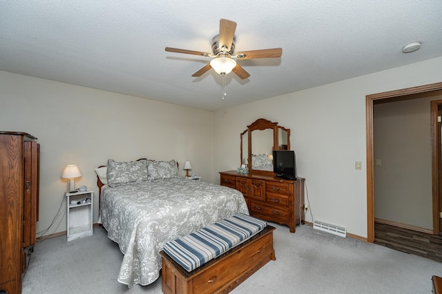 bedroom featuring ceiling fan, visible vents, baseboards, and light carpet