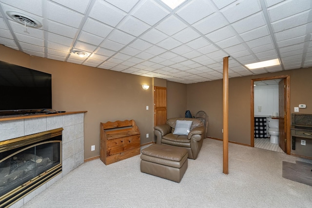 living area featuring a drop ceiling, visible vents, and carpet floors