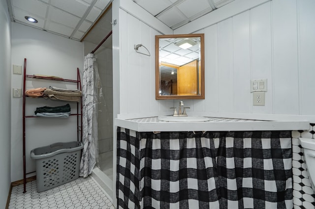 bathroom with tile patterned floors, toilet, a paneled ceiling, and a shower with curtain