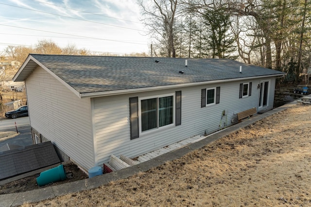 rear view of property featuring roof with shingles