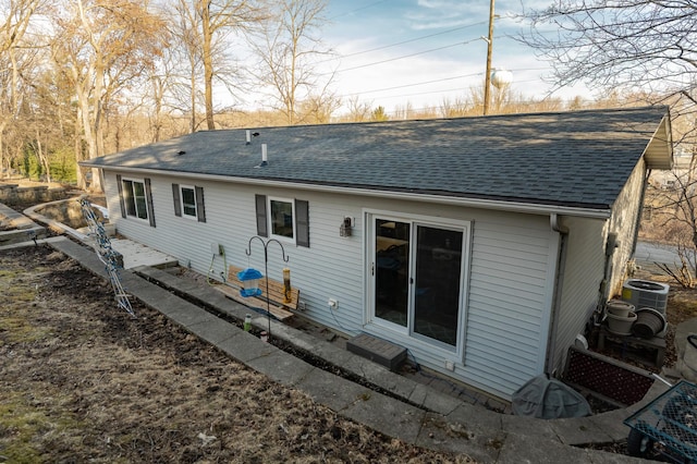 back of property featuring central air condition unit and roof with shingles