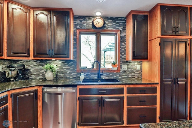 kitchen featuring dishwasher, dark stone countertops, tasteful backsplash, and a sink