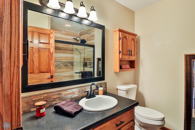 bathroom featuring tasteful backsplash, a stall shower, toilet, and vanity