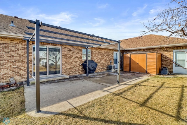 rear view of property with a patio, an outbuilding, cooling unit, a shed, and brick siding