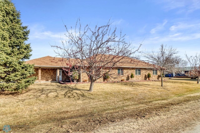 ranch-style house featuring brick siding and a front lawn