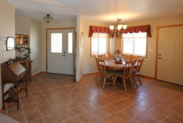 dining room featuring tile patterned flooring, a notable chandelier, baseboards, and a textured ceiling