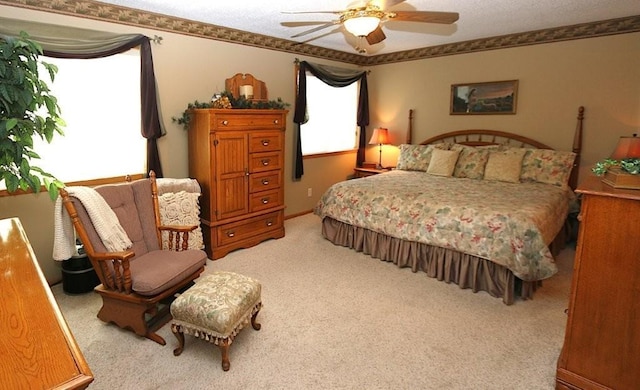 bedroom featuring light carpet, ornamental molding, and a ceiling fan