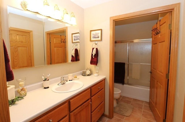 full bath with vanity, tile patterned floors, toilet, and shower / bath combination with glass door