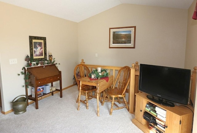 dining space featuring light colored carpet, baseboards, and vaulted ceiling