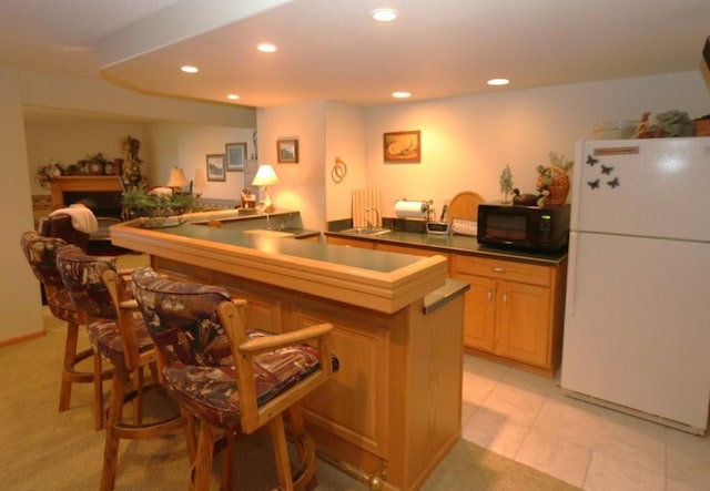 bar with recessed lighting, a sink, black microwave, and freestanding refrigerator