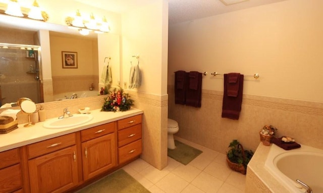 bathroom featuring a garden tub, toilet, a stall shower, tile patterned flooring, and vanity