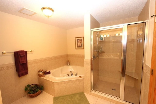 full bath featuring tile patterned floors, visible vents, a bath, and a shower stall