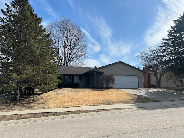 ranch-style house featuring a garage and driveway