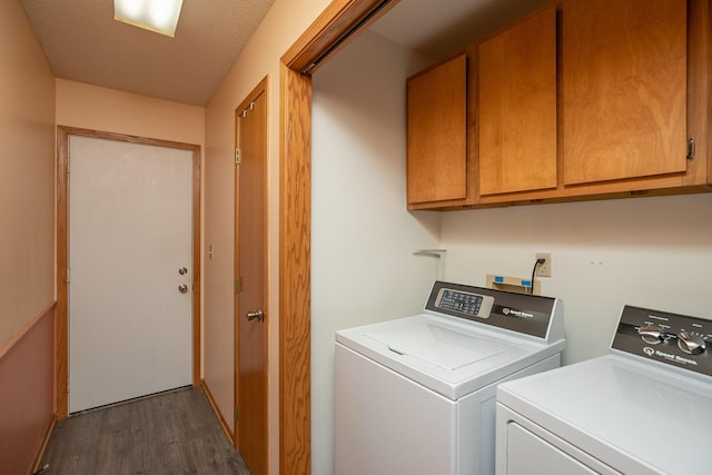 laundry area with washing machine and clothes dryer, cabinet space, and dark wood-style flooring