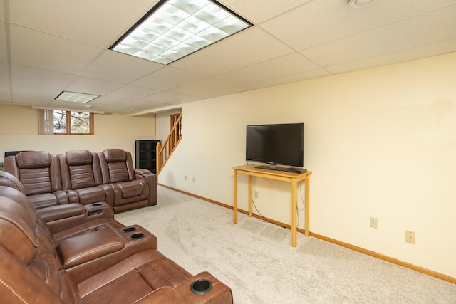 living area with carpet flooring, stairs, baseboards, and a drop ceiling